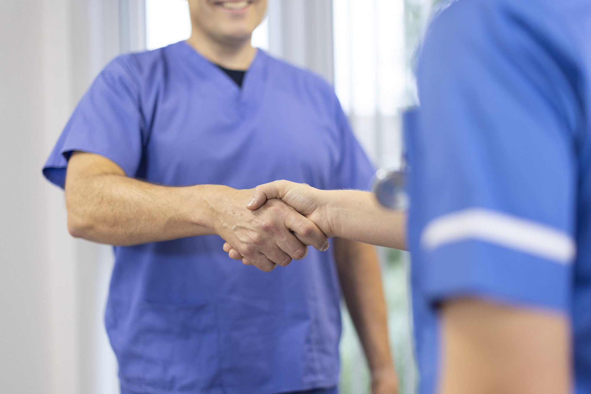 Two medical staff shaking hands
