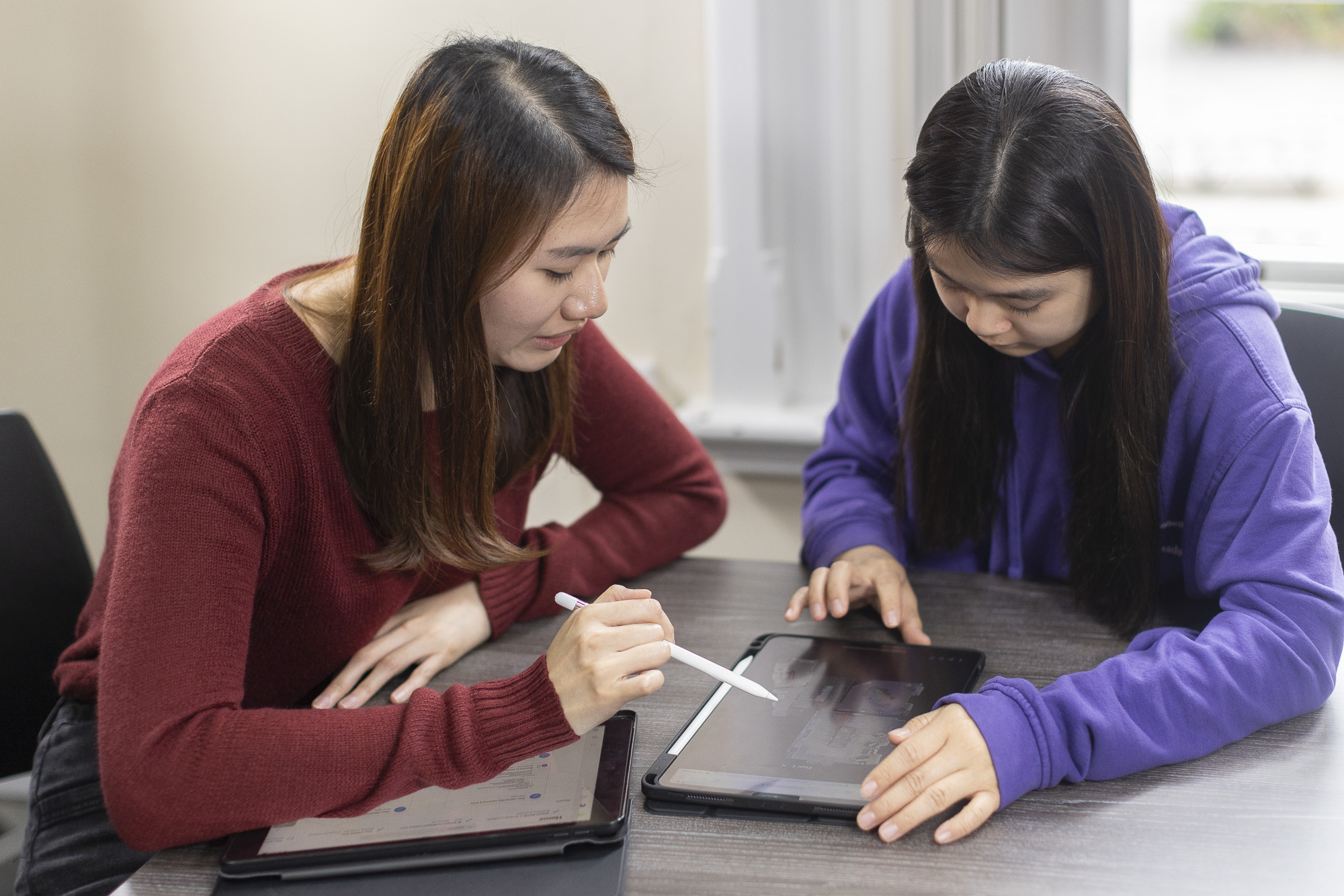Students writing on an ipad