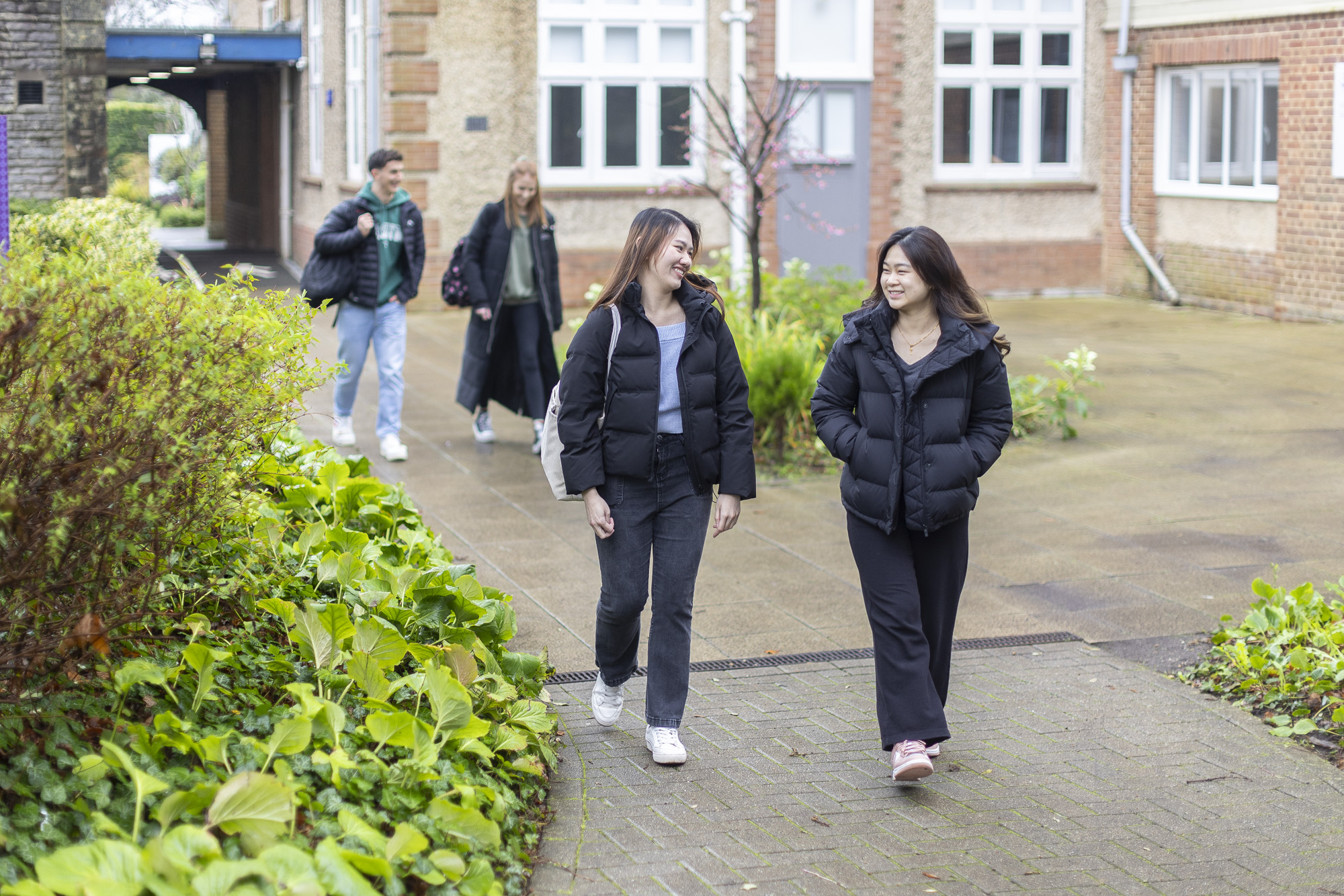 Students outside the main campus building, walking around