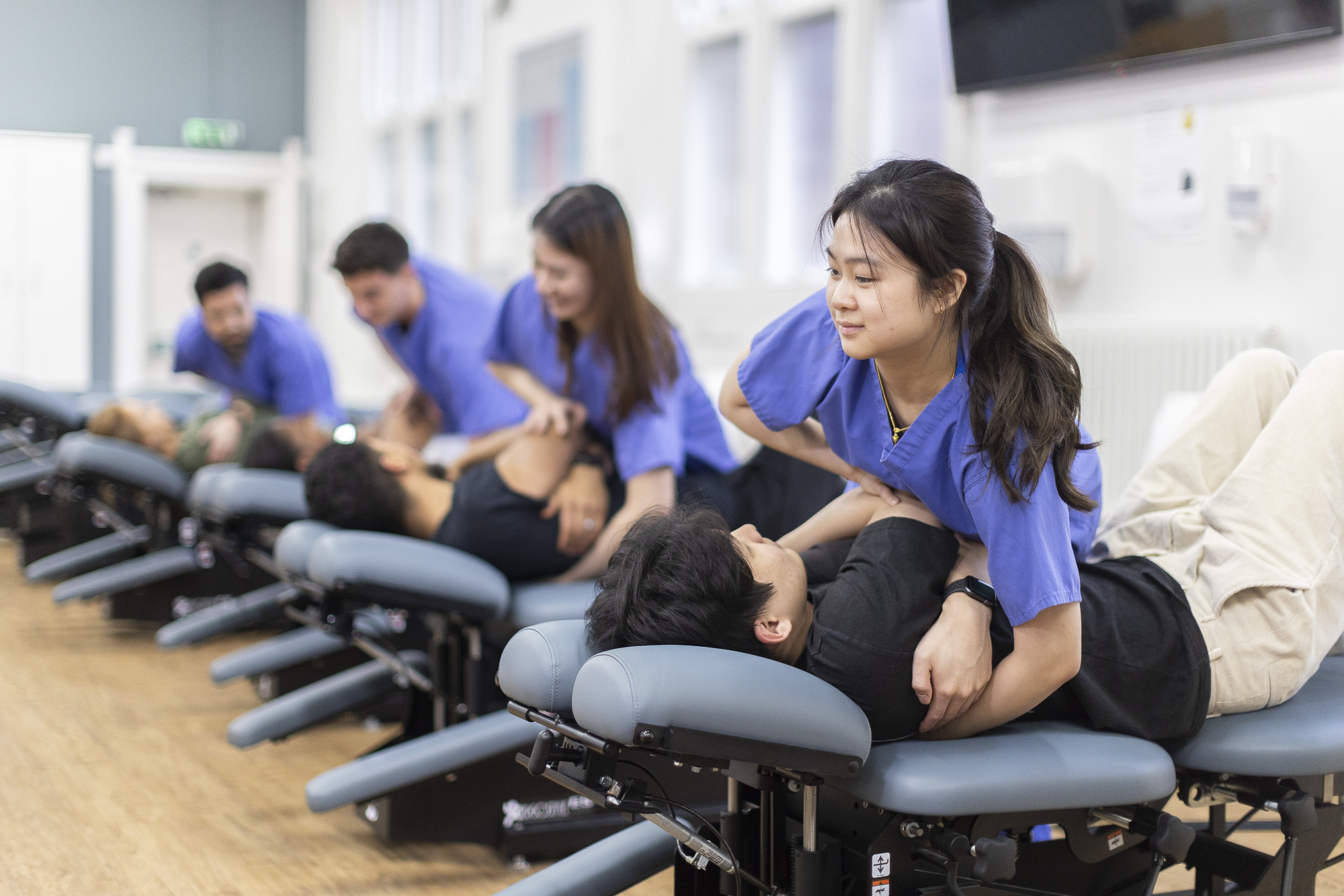 Photo of a practical chiropractic class of students taking place